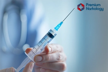 Врач держит в руке шприц